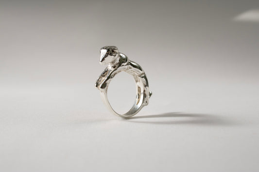 Silver ring with a unique design on a gray background