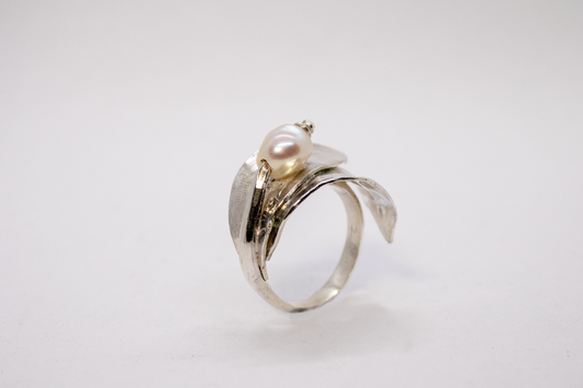 Silver ring with a pearl on a light gray background