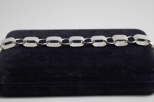 Silver chain on a black velvet box against a light gray background